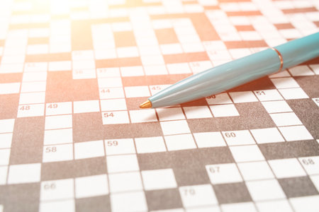 Ballpoint pen on background crossword puzzle sheet in the contoured sunlightの写真素材