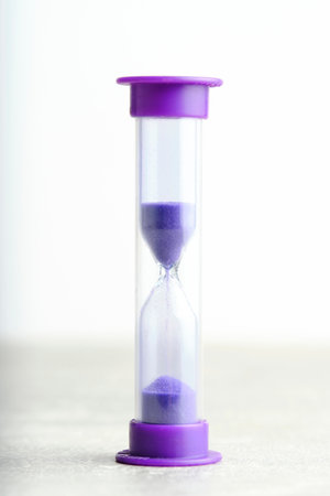 Hourglass for one minute purple on light background