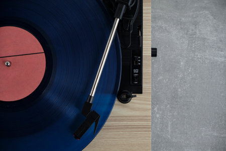 Vinyl record player with blue record installed top view gray background