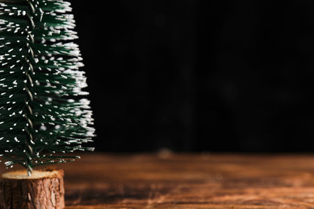 Decorative green Christmas tree covered with snow dark background. Christmas decorationの写真素材