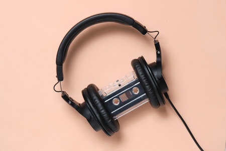 Headphones and an audio cassette beige retro background