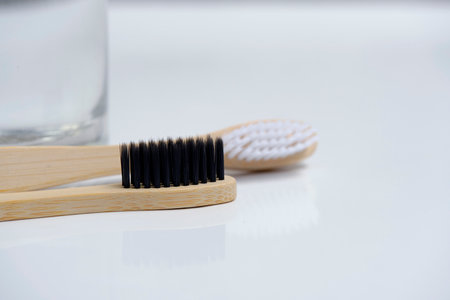 Glass water and two wooden toothbrushes bathroom on a white backgroundの写真素材