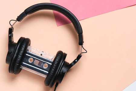 Headphones and an audio cassette beige retro backgroundの写真素材