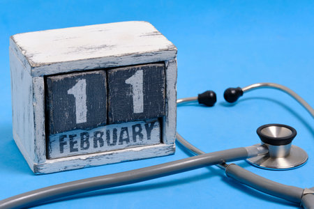 Date is February 11th on calendar and a stethoscope on blue background. World Sick Day.の写真素材