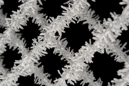 Mesh of chain link covered with frost after severe frost. Macro photographyの写真素材