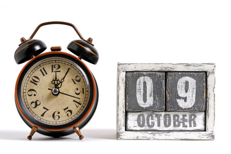 October 09 on wooden calendar with alarm clock white backgroundの写真素材
