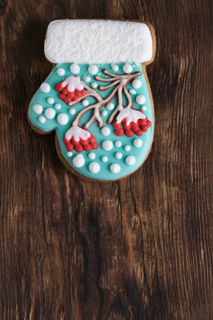 Christmas cookies in shape mitten, decorated with icing depicting rowan tree, sprinkled with snow. Magic holiday every sweet detailの写真素材