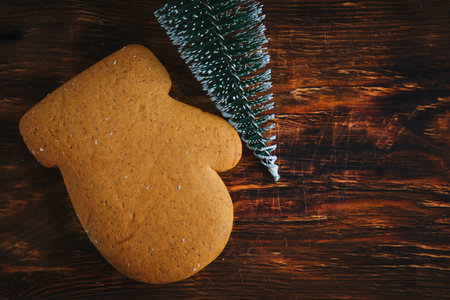 Cookies form of mittens and Christmas tree on wooden background