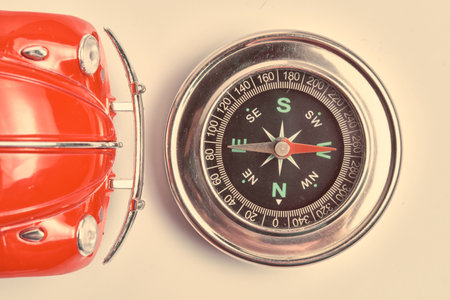 Hood red car and compass pointing west. Concept traveling by car.