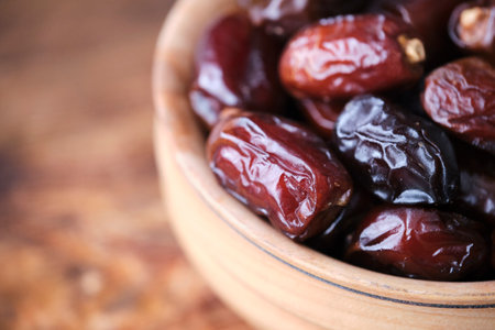 Dried dates in wooden cup. Fruits and healthy foodの写真素材