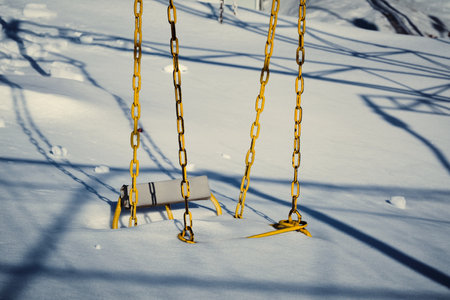 Chain swing is covered with snowの写真素材