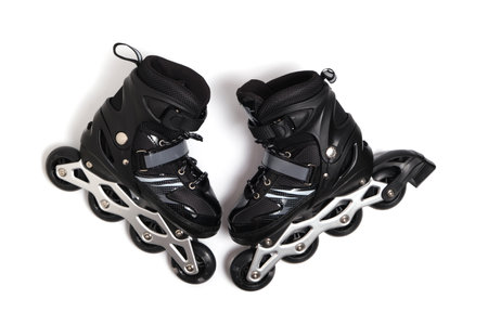 Pair of black children roller skates on white background, representing fun, activity, and youthfulnessの写真素材