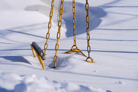 Chain swing is covered with snowの写真素材