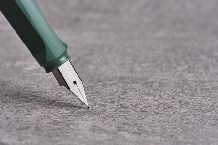 Green fountain pen on gray concrete backgroundの写真素材