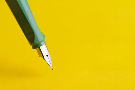 Fountain pen is green on a yellow backgroundの写真素材
