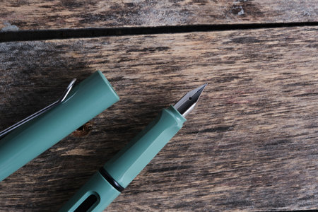 Green fountain pen wooden backgroundの写真素材