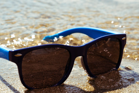 Sunglasses on the sand at the beach. Selective focus.