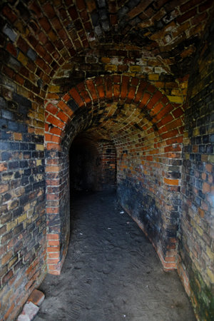Inside view of an old red brick wall with a narrow passage.の写真素材