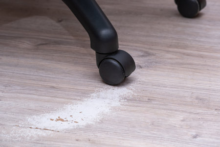 Worn and damaged parquet on the floor from rollers  computer chair.の写真素材