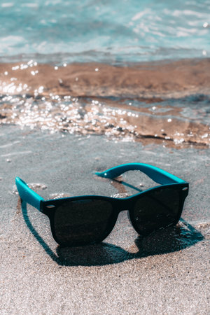 Sunglasses on the sand by the sea. Selective focus.の写真素材