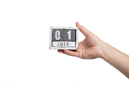 Hand holding wooden calendar isolated on a white background with clipping path.