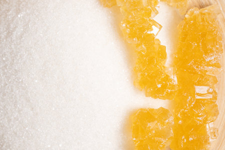 Sugar cubes and candied orange slices on a wooden background.の写真素材