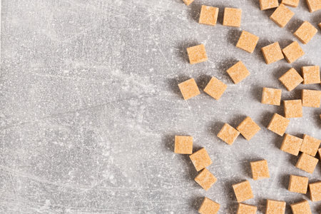 Brown sugar cubes on a gray background. Top view. Copy space.の写真素材