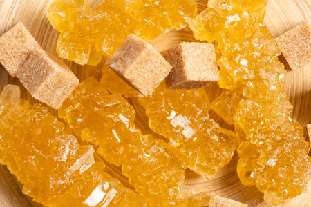 Cubes of caramelized sugar on a wooden plate. Close-up.の写真素材