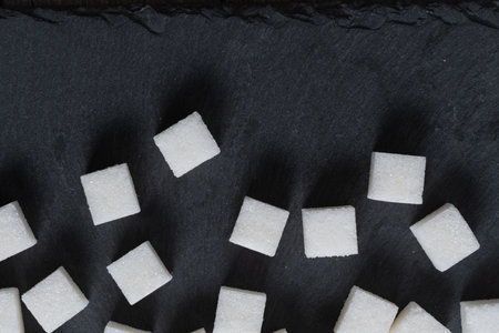 Sugar cubes on black background. Top view, flat lay.の写真素材