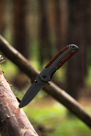 Hunting knife in the forest close-up on a blurred background