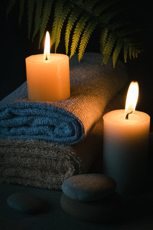 Spa still life with candles, towel, stones and fernの写真素材