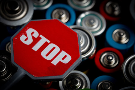 Close-up of red stop sign on a group of alkaline batteries