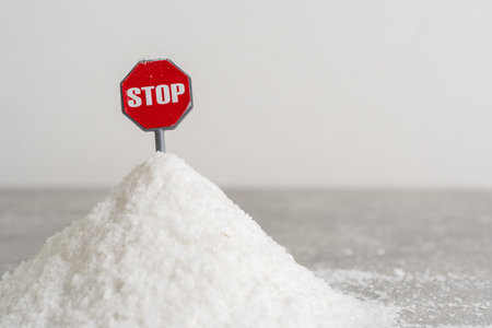 Red stop sign on pile of salt on gray background. Concept  salt consumption.の写真素材
