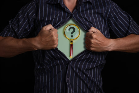 Man opening his shirt to show a question mark and a magnifying glass