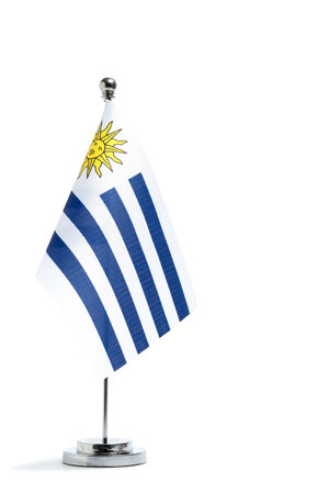 Uruguay flag on a metal flagpole isolated on white background.の写真素材