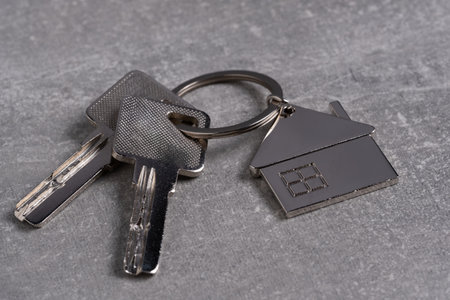 Keychain with house keys on a gray background. Real estate concept.