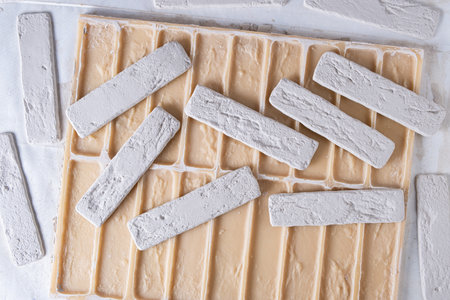 Tiles of white decorative brick on background  silicone mold. View from above.