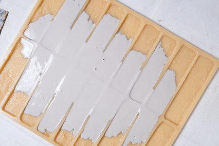 Pouring gypsum into a mold for making decorative bricks.の写真素材