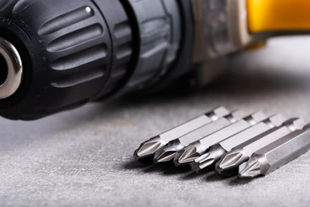 Set of drill bits and screwdriver on a gray background close upの写真素材