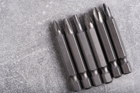 Set of various drill bits on grey background. Copy space for text.