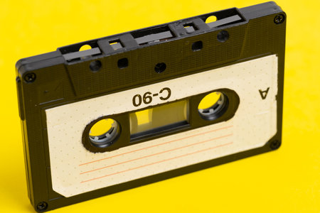 Vintage audio cassette tape on a yellow background. Close up.