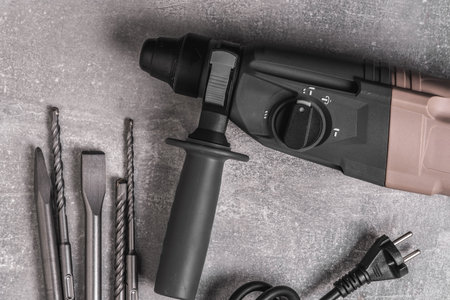 Cordless screwdriver with different tools on grey background, top viewの写真素材