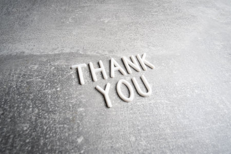 Thank you text made of white wooden letters on concrete background, copy space