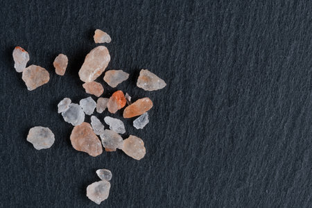 Heap of sea salt crystals on black slate background, top viewの写真素材