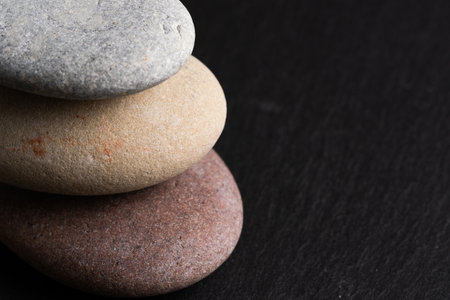 Stack of pebbles on black stone background. Zen concept.の写真素材