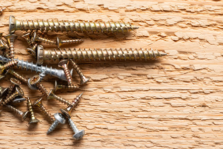 screws on a wooden background, close-up, construction concept