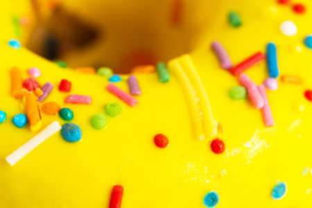 Colorful sprinkles on a yellow donut. Selective focus.の写真素材