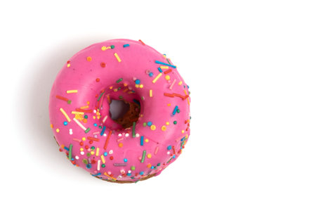 Pink donut with sprinkles isolated on white background. Top view.の写真素材