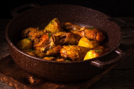 Baked chicken legs with potatoes in  cast iron pan.の写真素材