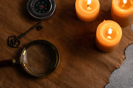 Vintage key, compass, magnifying glass and candles on background  old paper.の写真素材